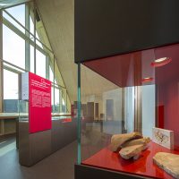 Vue d'un autre angle de l'une des salle d'exposition du CIP La Villa, musée d'archéologie à Dehlingen, présentant des pièces archéologiques retrouvées sur le site du Gurtelbach, au premier plan, des tuiles provenant de la villa